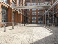 a cobblestone paved courtyard with brick floors and a bridge for traffic to pass