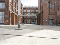 a cobblestone paved courtyard with brick floors and a bridge for traffic to pass