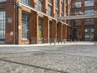 a cobblestone paved courtyard with brick floors and a bridge for traffic to pass