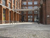 a cobblestone paved courtyard with brick floors and a bridge for traffic to pass