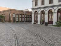 a cobblestone paved plaza and buildings in the middle of downtown with a city skyline