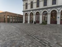 a cobblestone paved plaza and buildings in the middle of downtown with a city skyline