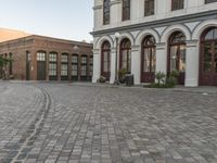 a cobblestone paved plaza and buildings in the middle of downtown with a city skyline