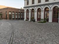 a cobblestone paved plaza and buildings in the middle of downtown with a city skyline