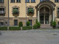 large yellow building with some plants and bushes in front of it for decoration or entertainment