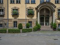 large yellow building with some plants and bushes in front of it for decoration or entertainment