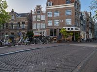 several bicycle racks sit along side a cobblestone road in the middle of a city