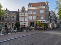 several bicycle racks sit along side a cobblestone road in the middle of a city