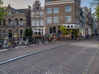 several bicycle racks sit along side a cobblestone road in the middle of a city