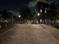 a cobblestone road in front of parked bicycles at night or early mornings, in an urban area