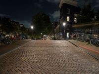 a cobblestone road in front of parked bicycles at night or early mornings, in an urban area