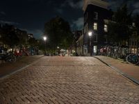 a cobblestone road in front of parked bicycles at night or early mornings, in an urban area