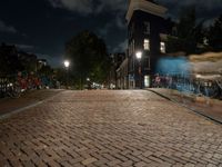 a cobblestone road in front of parked bicycles at night or early mornings, in an urban area