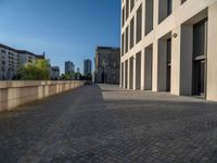 an empty sidewalk near buildings in a city area of europe, in front of blue sky