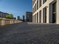 an empty sidewalk near buildings in a city area of europe, in front of blue sky