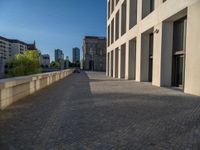 an empty sidewalk near buildings in a city area of europe, in front of blue sky