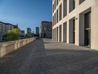 an empty sidewalk near buildings in a city area of europe, in front of blue sky