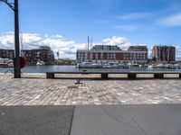 a brick road with stone steps in between parked boats on the side of it, a street lamp and buildings in the background