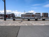 a brick road with stone steps in between parked boats on the side of it, a street lamp and buildings in the background