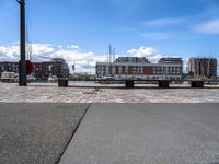 a brick road with stone steps in between parked boats on the side of it, a street lamp and buildings in the background