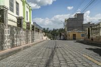 a motorcycle drives down an old brick road between two buildings in the city, with some buildings behind them