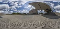 a very big and neat looking circular building in the middle of the park with a blue sky background