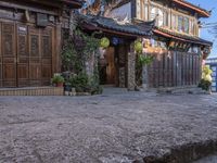 a brick walkway and house with a tree in the background during sunset in china, asia