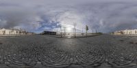 this is a fisheye lens photo of a person riding his skateboard on an empty street