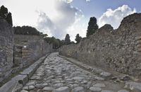 a cobblestone road that has stones all over it and trees around it, in an ancient city
