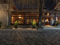 a house with large glass doors in a courtyard at night and a fire hydrant in the front