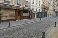 two black post's on a cobble - stone road in paris, france