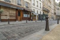 two black post's on a cobble - stone road in paris, france