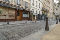 two black post's on a cobble - stone road in paris, france