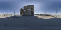 an upside down skateboarder does tricks on a parking lot next to a large building