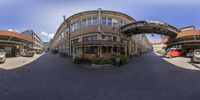 a photo of buildings and cars on the street from the fish eye view point of a street