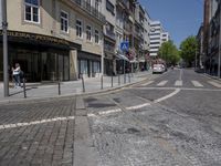 a city street with an empty intersection on the corner of it and parked cars on either side