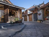 an old fashioned street scene with stone steps and pots of plants on either side of the walkway