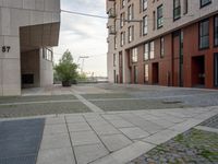 the sidewalk is made out of cobbles and sidewalking pavements, with many buildings in background