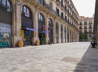 a cobblestone street in an european city on a sunny day with pedestrians on the sidewalk