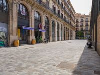 a cobblestone street in an european city on a sunny day with pedestrians on the sidewalk