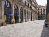 a cobblestone street in an european city on a sunny day with pedestrians on the sidewalk