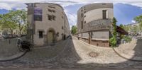 a street with cobblestones and bikes parked on each side of the road under a blue sky