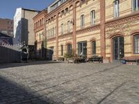 a cobblestone street in front of an old building on a sunny day,