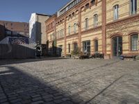 a cobblestone street in front of an old building on a sunny day,