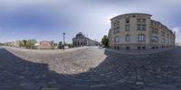 a 360 - view is of a cobblestone street with buildings on either side