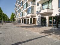 there is an empty brick street with lots of windows and a sidewalk near a building