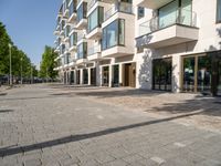 there is an empty brick street with lots of windows and a sidewalk near a building