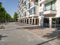 there is an empty brick street with lots of windows and a sidewalk near a building