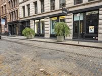 a cobblestone street and some buildings are shown at the intersection of two roads