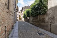 narrow cobblestone street in front of old buildings with a sky background with a sky line showing